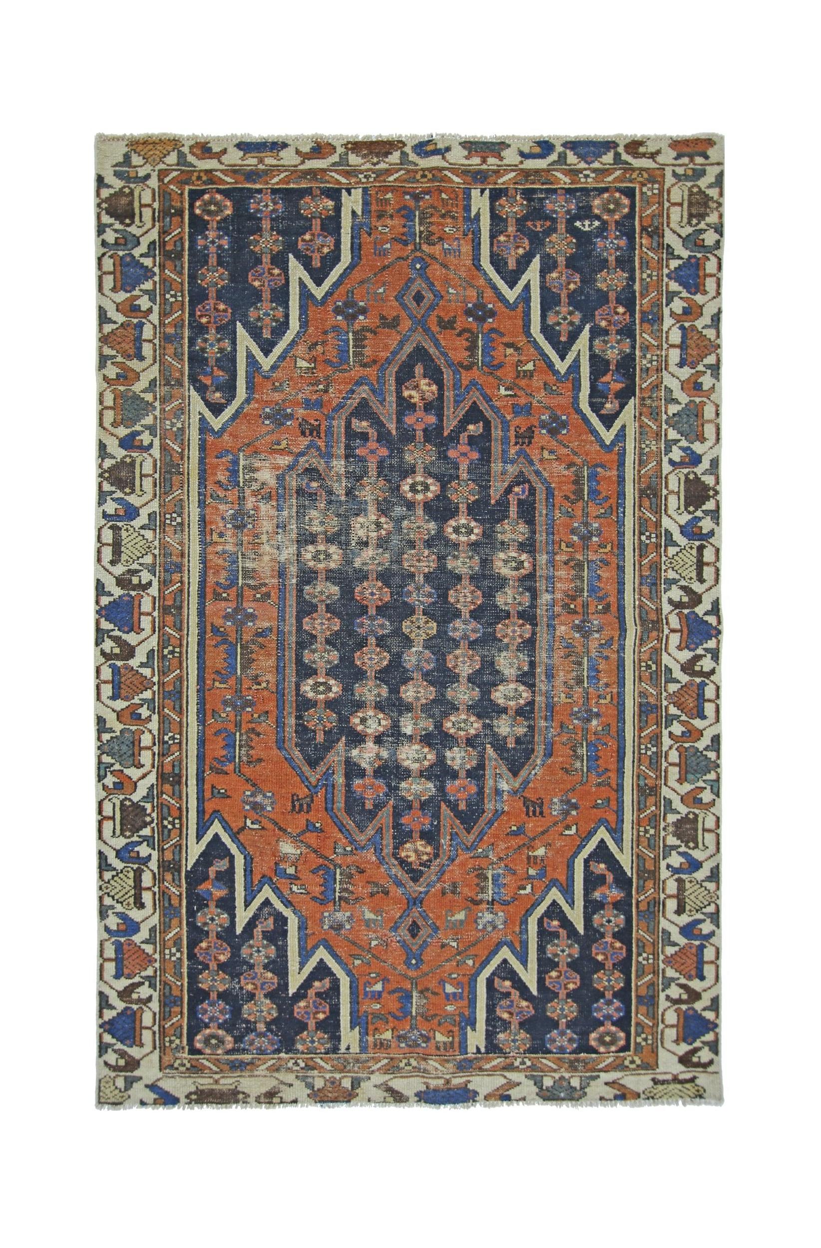 A vintage Persian Mazlaghan rug featuring a geometric medallion in rust orange and navy blue.