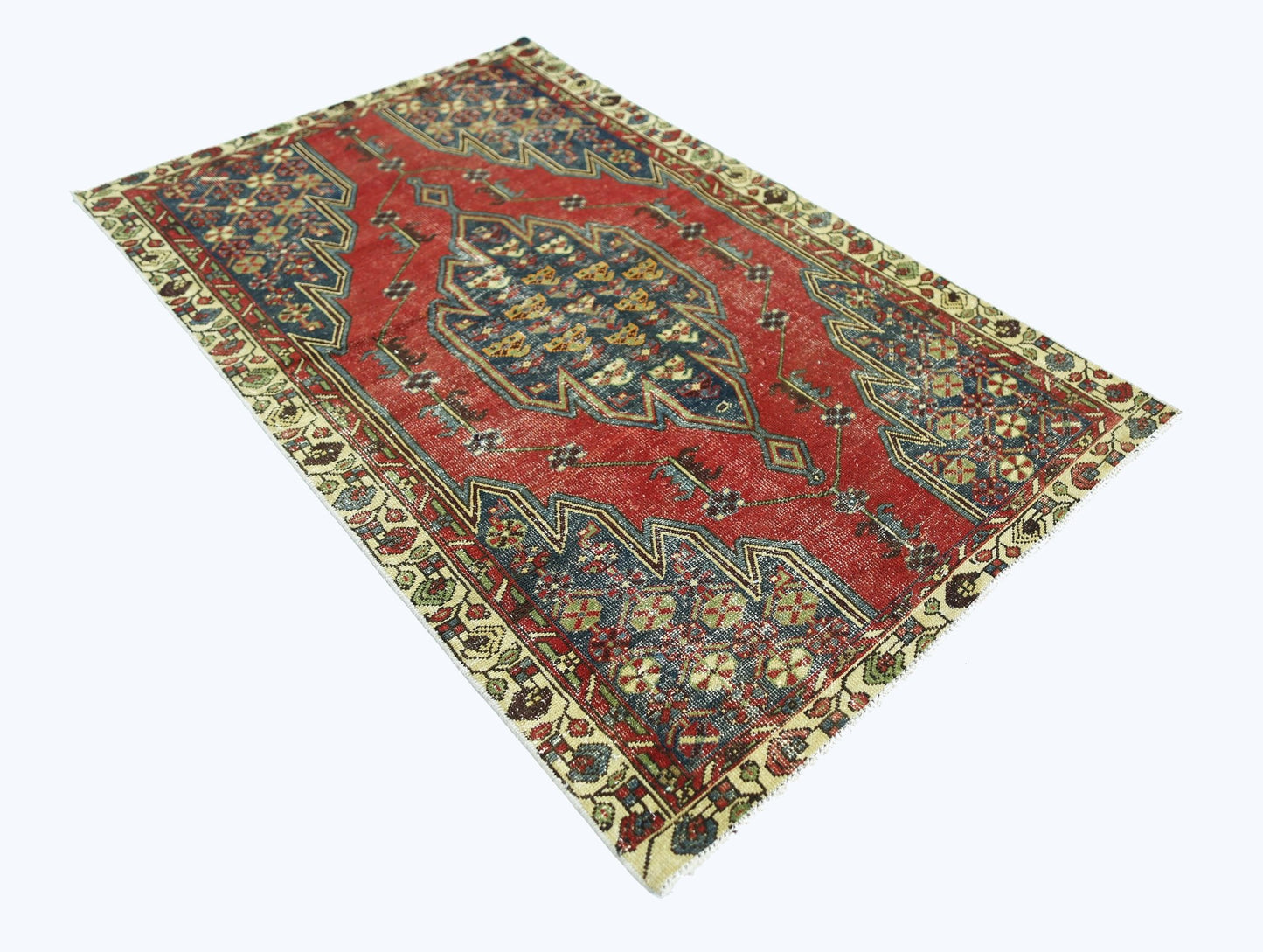 A vintage Persian Mazlaghan rug featuring a central blue medallion on a red field.