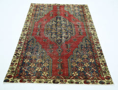 A vintage Persian Mazlaghan rug featuring a central geometric medallion on a red field.