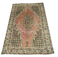 A vintage Persian Mazlaghan rug featuring a geometric diamond medallion on a pink and brown field.