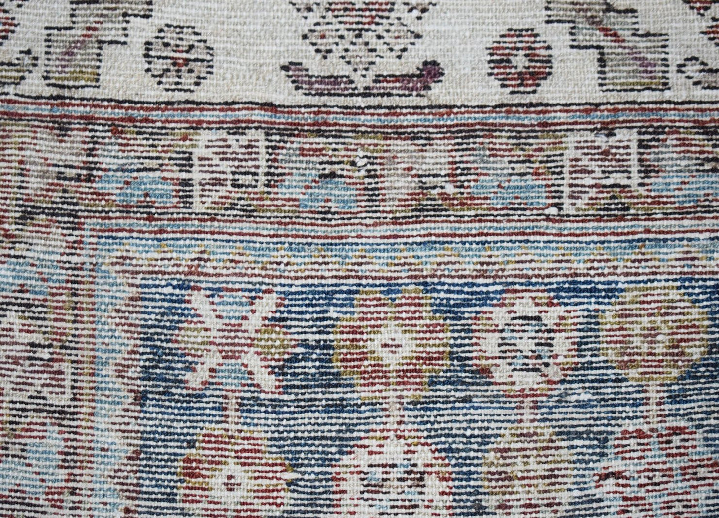 A close-up of a vintage Persian Mazlaghan rug featuring intricate geometric patterns in wool.