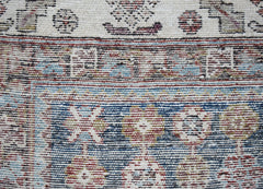 A close-up of a vintage Persian Mazlaghan rug featuring intricate geometric patterns in wool.