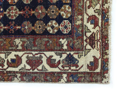 A vintage Persian Mazlaghan rug featuring a dark blue field with geometric floral motifs.