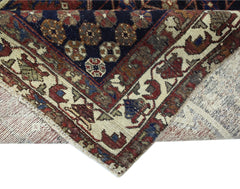 A vintage Persian Mazlaghan rug featuring a dark blue field with geometric floral motifs.