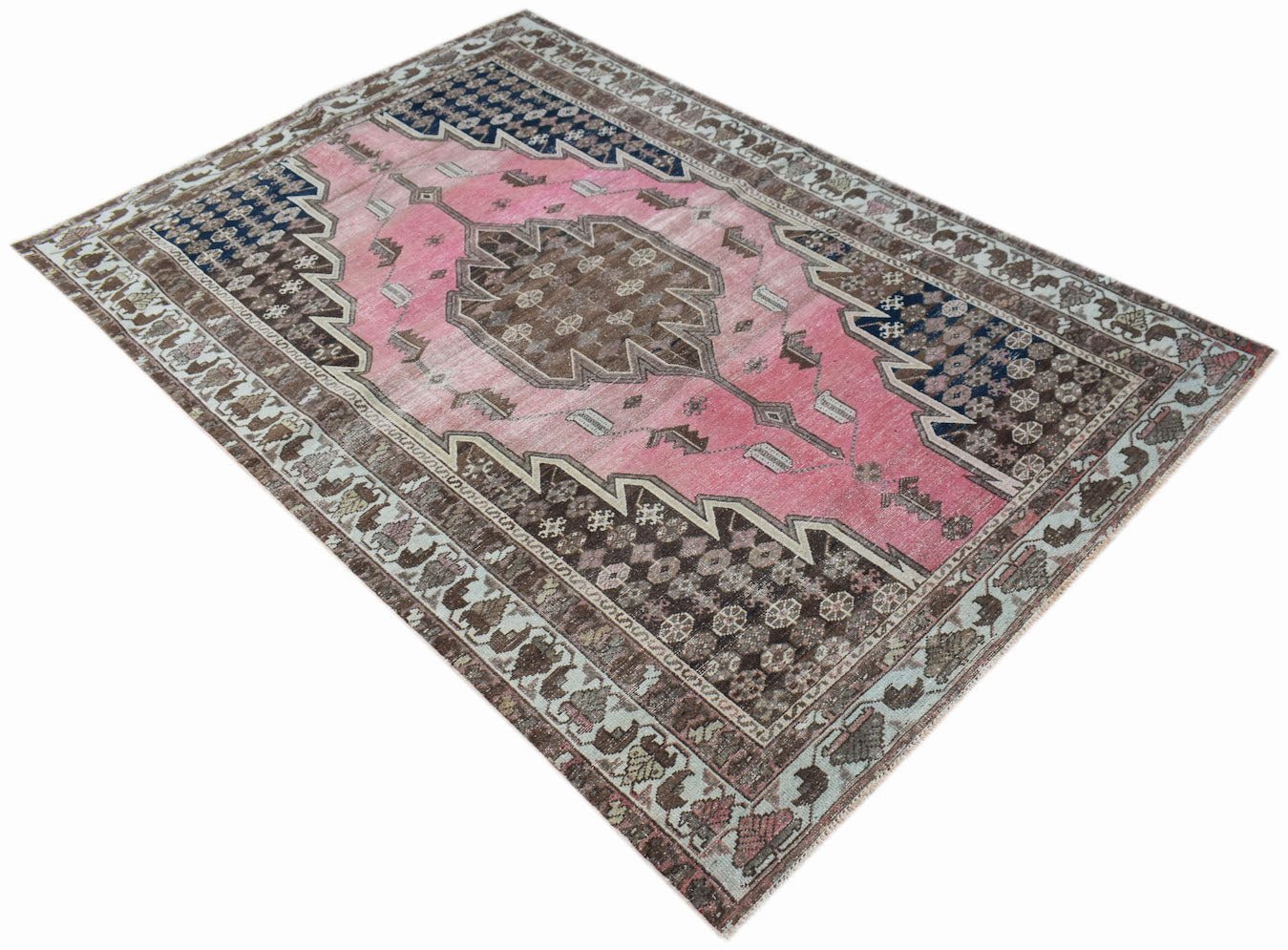 A vintage Persian Mazlaghan rug featuring a central brown medallion on a pink field.