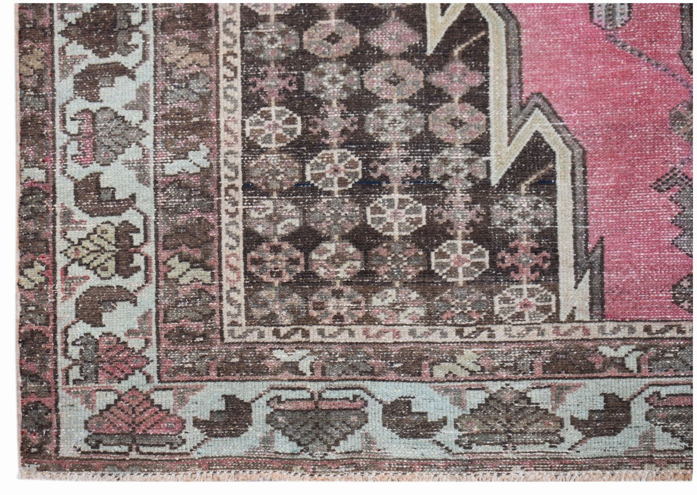 A vintage Persian Mazlaghan rug featuring a geometric pattern in shades of pink, brown, and cream.