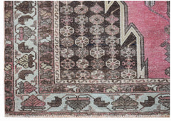 A vintage Persian Mazlaghan rug featuring a geometric pattern in shades of pink, brown, and cream.