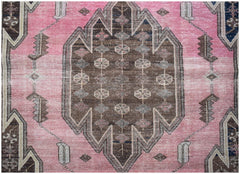 A vintage handwoven Persian Mazlaghan rug featuring a central brown medallion on a pink field.