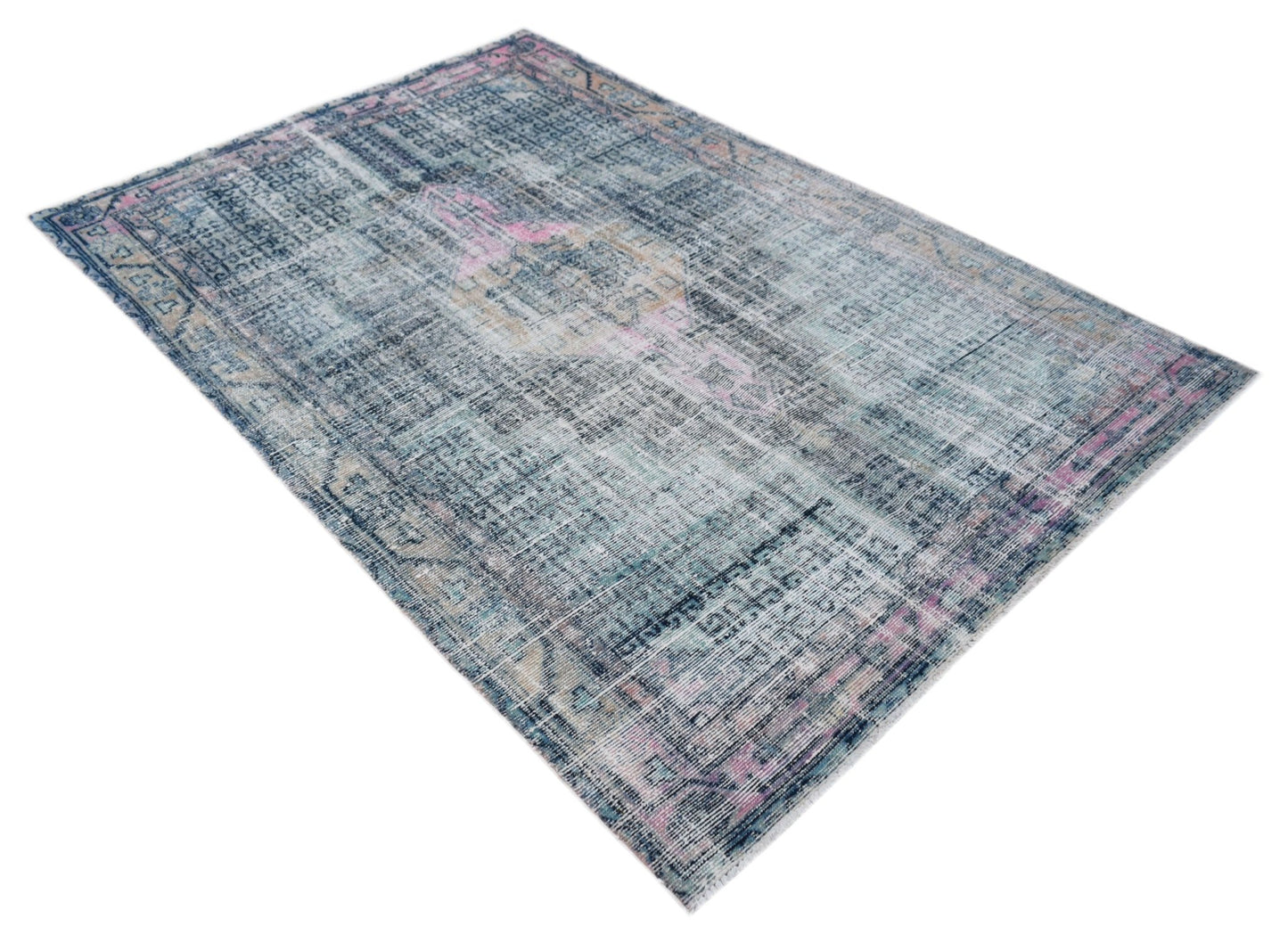 A vintage Persian rug featuring a distressed blue and pink pattern on a wool and cotton base.