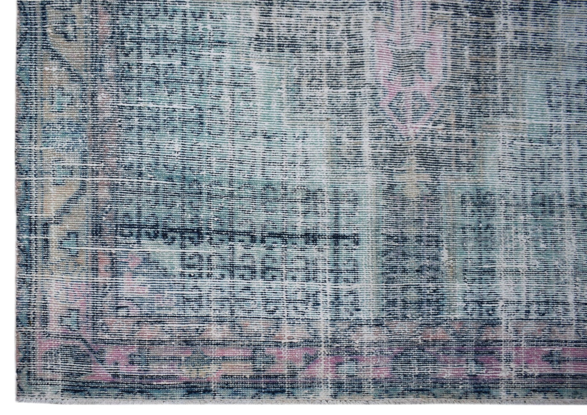 A vintage Persian rug featuring a distressed, faded pattern in shades of blue, pink, and cream.