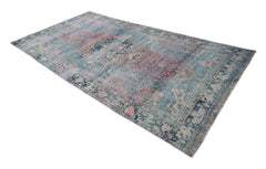 A vintage Persian Mazlaghan rug featuring a distressed pattern in shades of blue and pink.