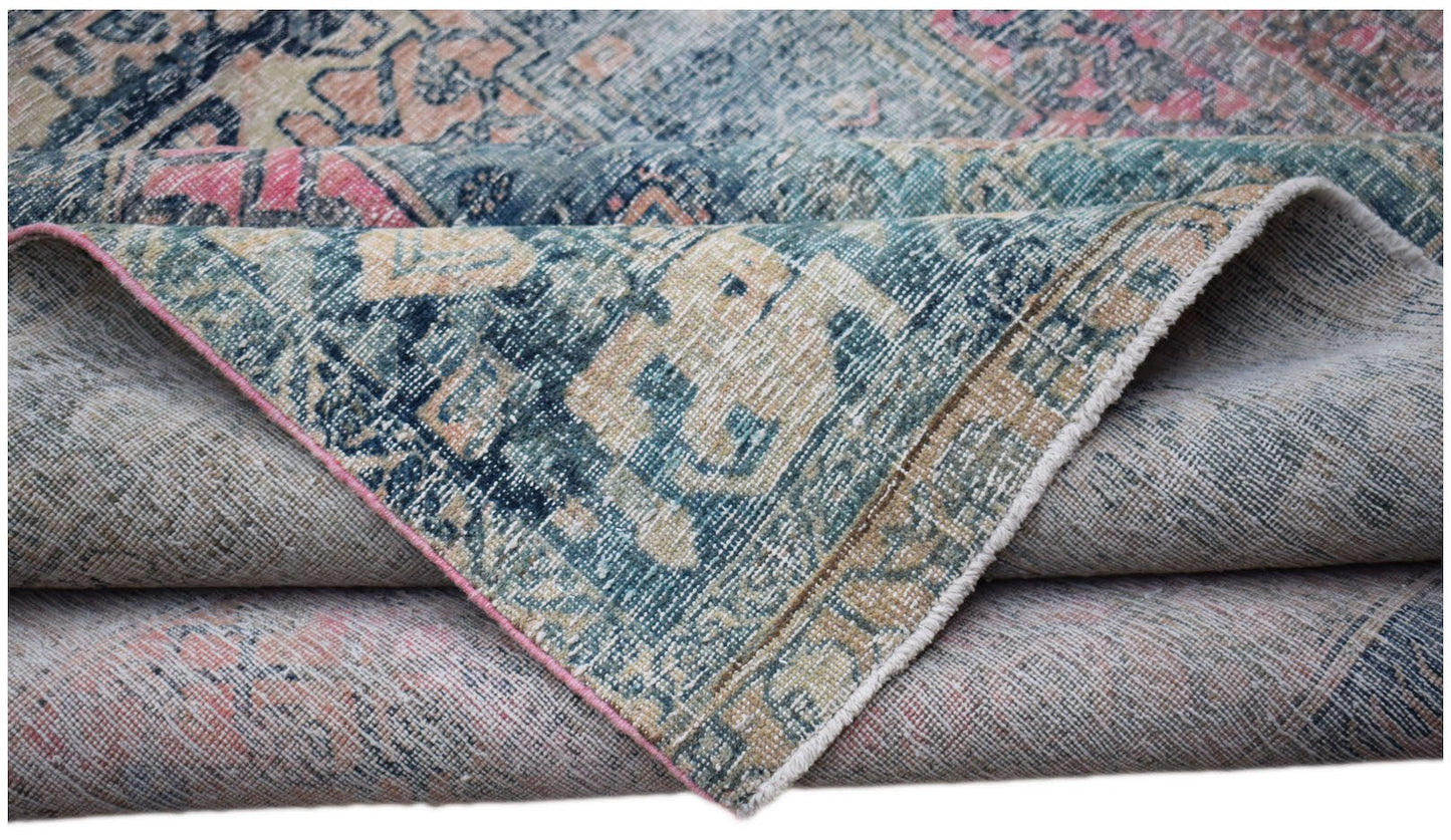 A vintage Persian Mazlaghan rug with a distressed blue, pink, and beige patterned wool pile.