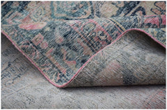 A vintage Persian Mazlaghan rug with a faded floral pattern in blue, pink, and cream tones.
