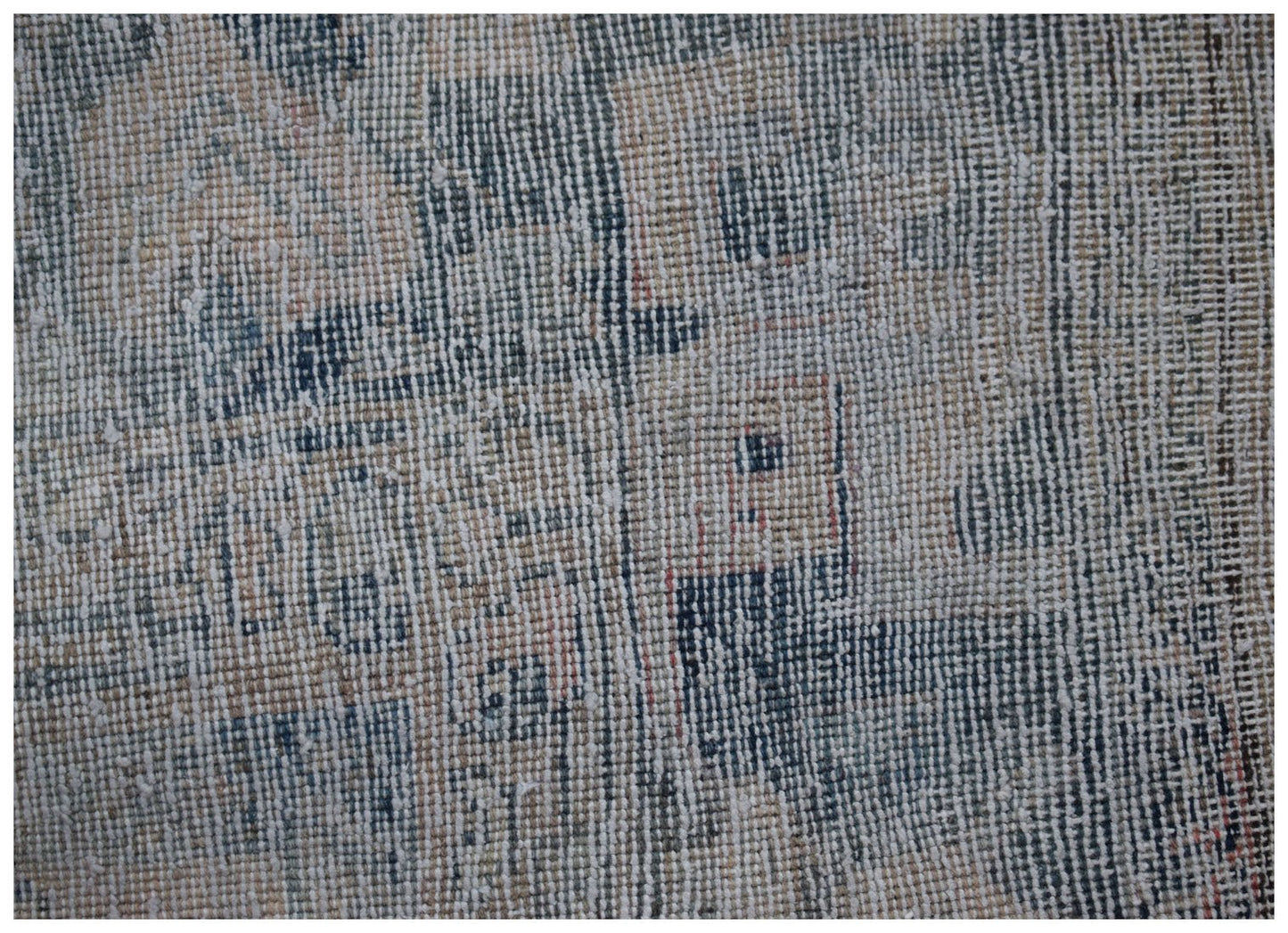 A close-up view of a vintage Persian Mazlaghan rug featuring a distressed blue and beige pattern.