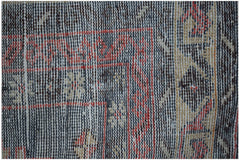 A close-up view of a vintage Persian rug featuring intricate geometric patterns in red and blue.