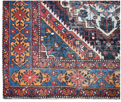 A handwoven vintage Persian rug featuring a geometric pattern in blue, red, and orange tones.