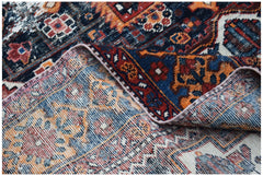 A vintage handwoven Persian rug featuring intricate geometric patterns in blue, orange, and red.