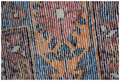 A close-up view of a handwoven vintage Persian rug featuring intricate geometric patterns.