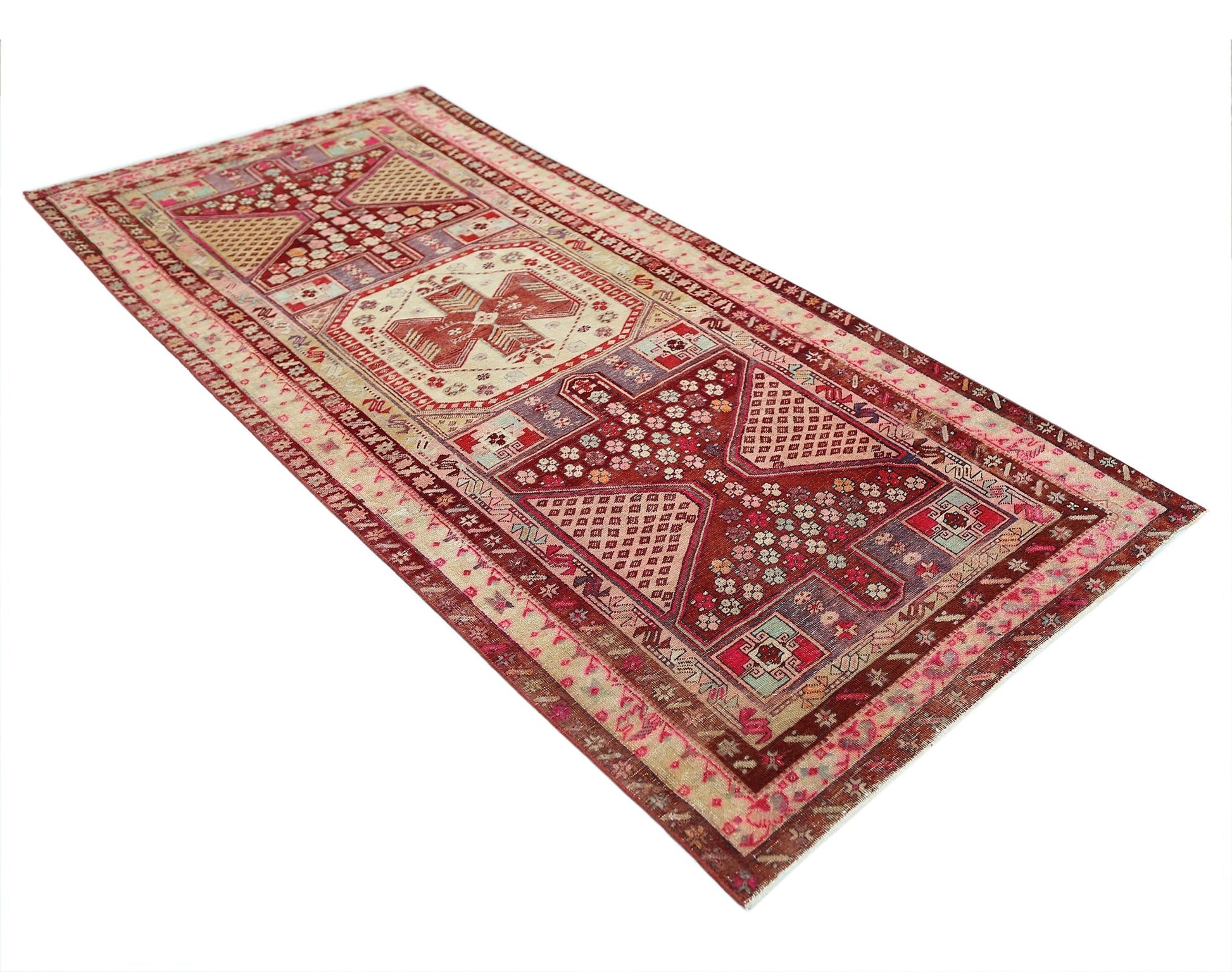 A rectangular vintage Persian rug featuring intricate geometric patterns in red and cream tones.