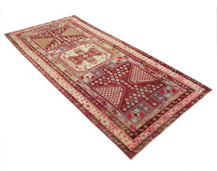 A rectangular vintage Persian rug featuring intricate geometric patterns in red and cream tones.