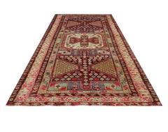 A vintage Persian runner rug featuring a geometric pattern in shades of red, beige, and blue.