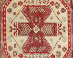A vintage Persian rug featuring a central geometric medallion in red and cream tones.