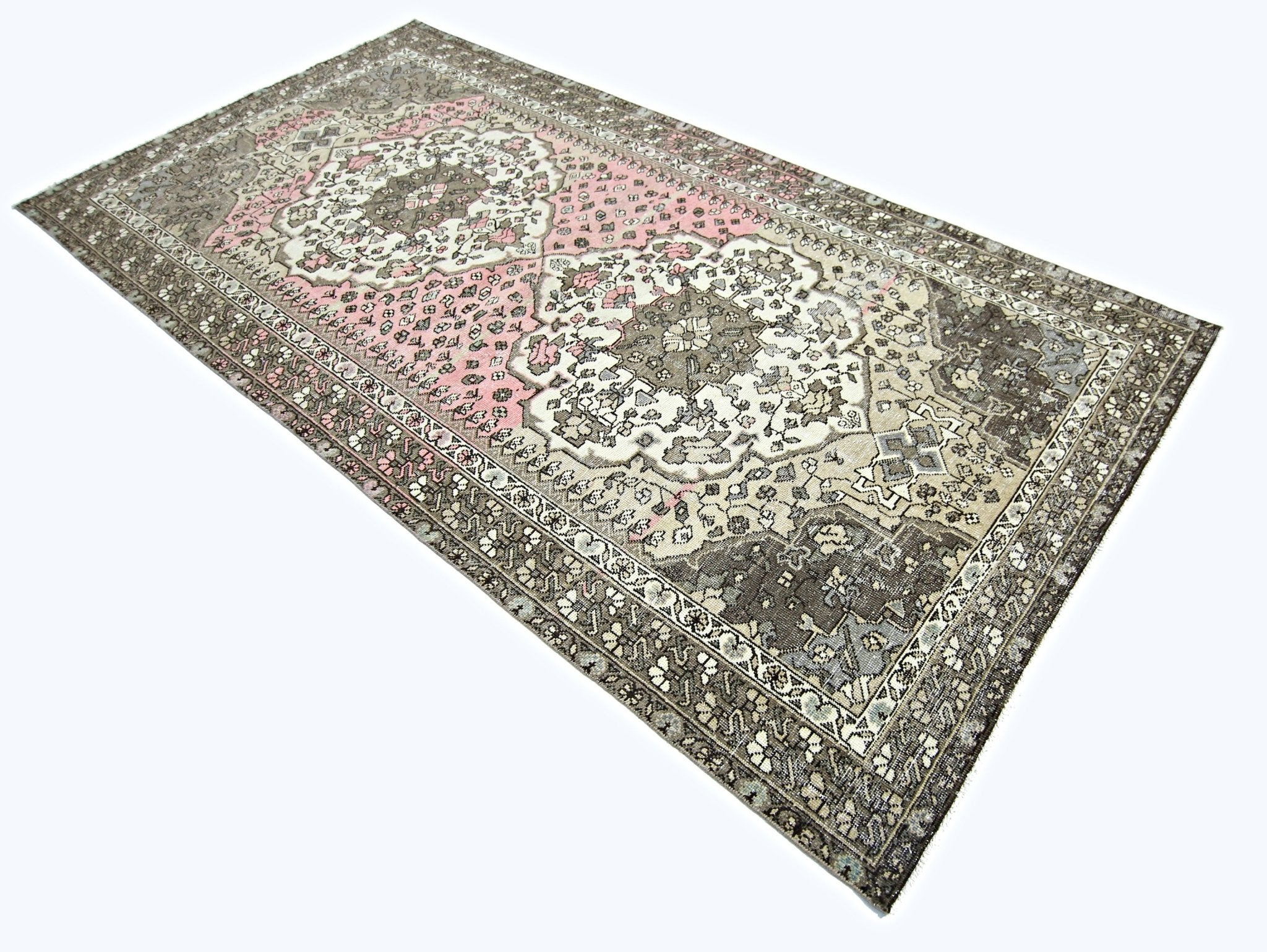 A rectangular vintage Persian rug featuring a floral pattern in shades of pink, grey, and cream.