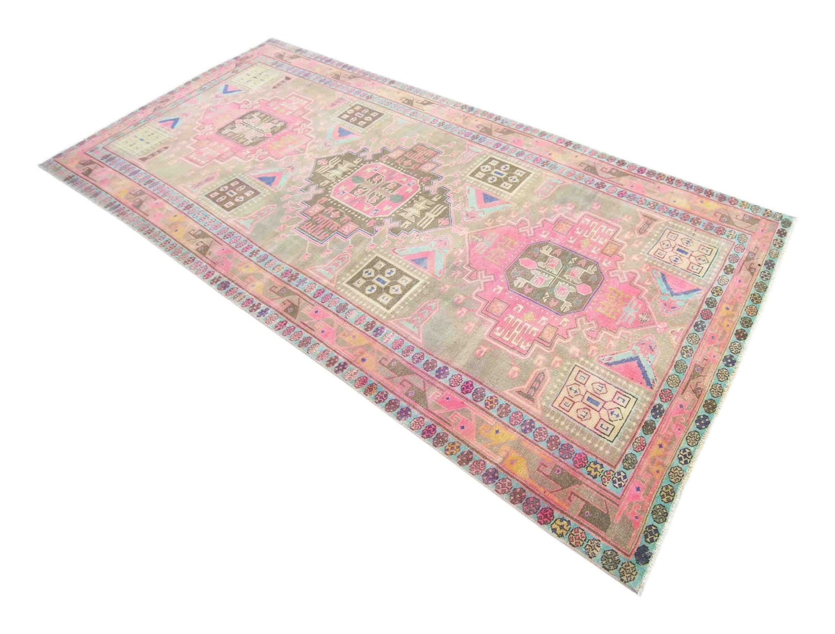 Vintage Persian Meshkin wool rug featuring a faded pink, blue, and earthy geometric pattern on a soft, worn pile.