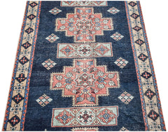 Vintage Persian Ardabil runner featuring geometric floral motifs in blue, pink, and cream.