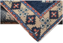 A vintage Persian Ardabil runner featuring a geometric pattern in blue, red, and beige wool.
