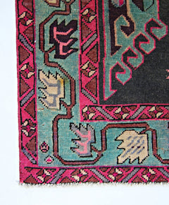 A vintage Persian Ardabil runner featuring a geometric floral pattern in vibrant pink and teal.