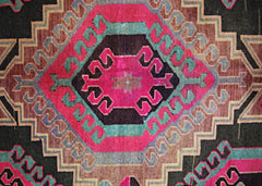 A vintage Persian Ardabil runner featuring a geometric medallion in vibrant pink, teal, and brown.