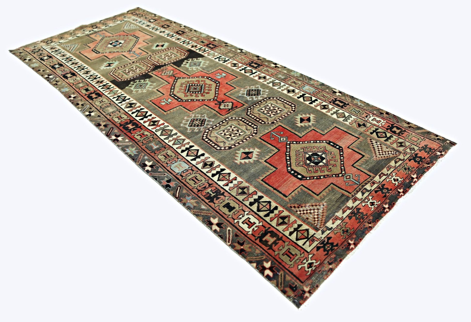 A vintage Persian Ardabil runner featuring geometric medallions in red and grey tones.