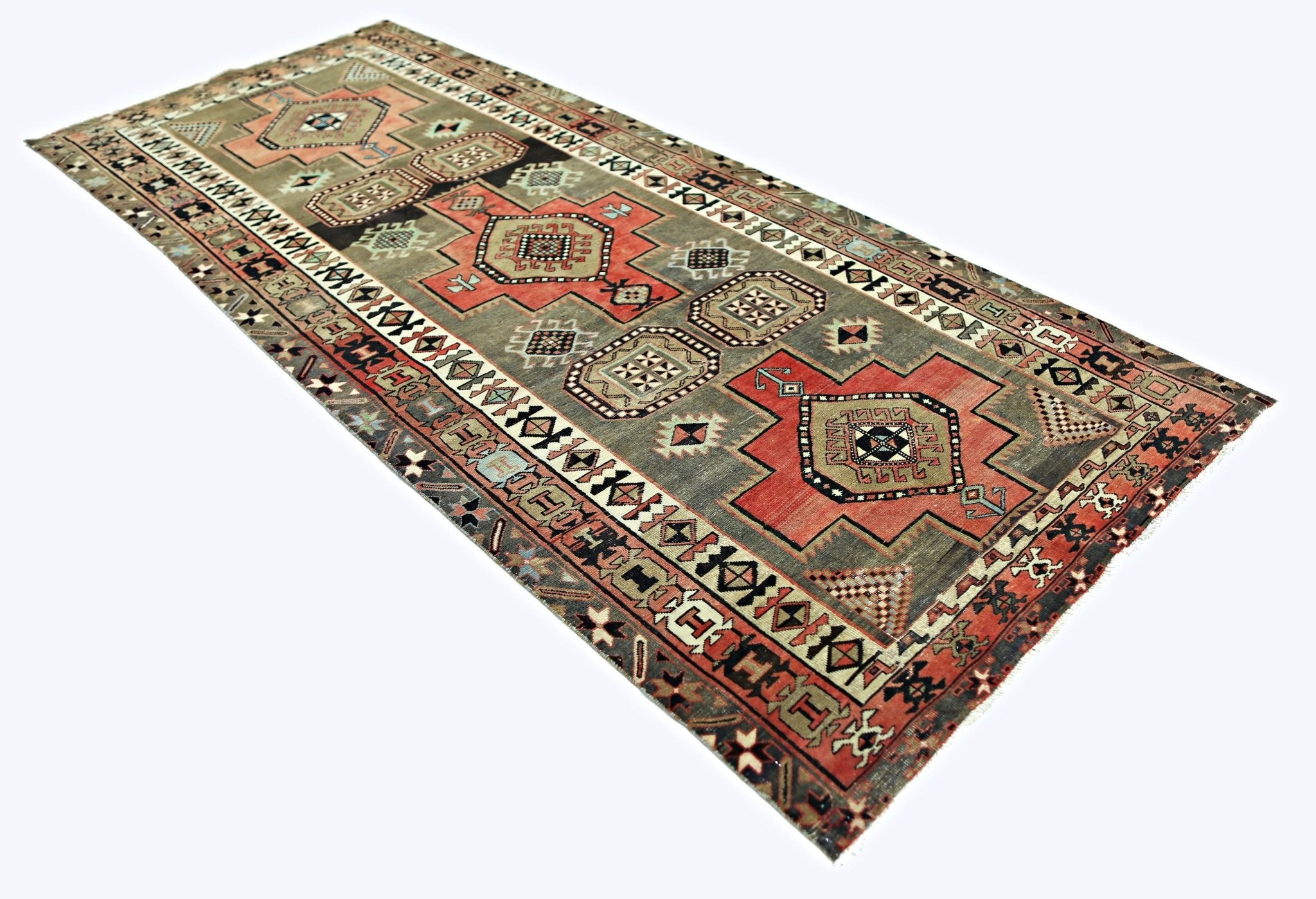 A vintage Persian Ardabil runner featuring geometric medallions in red and grey tones.