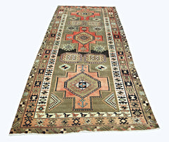 A vintage Persian Ardabil runner featuring geometric medallions in muted tones on a grey field.