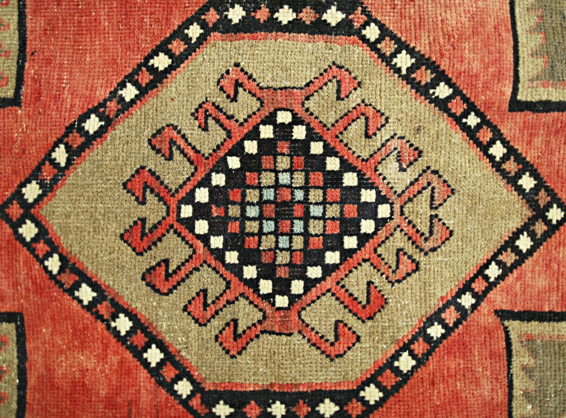 A vintage Persian Ardabil runner featuring a central geometric medallion with a checkered pattern.