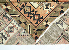 A vintage Persian Ardabil runner featuring geometric patterns in olive, orange, and black wool.