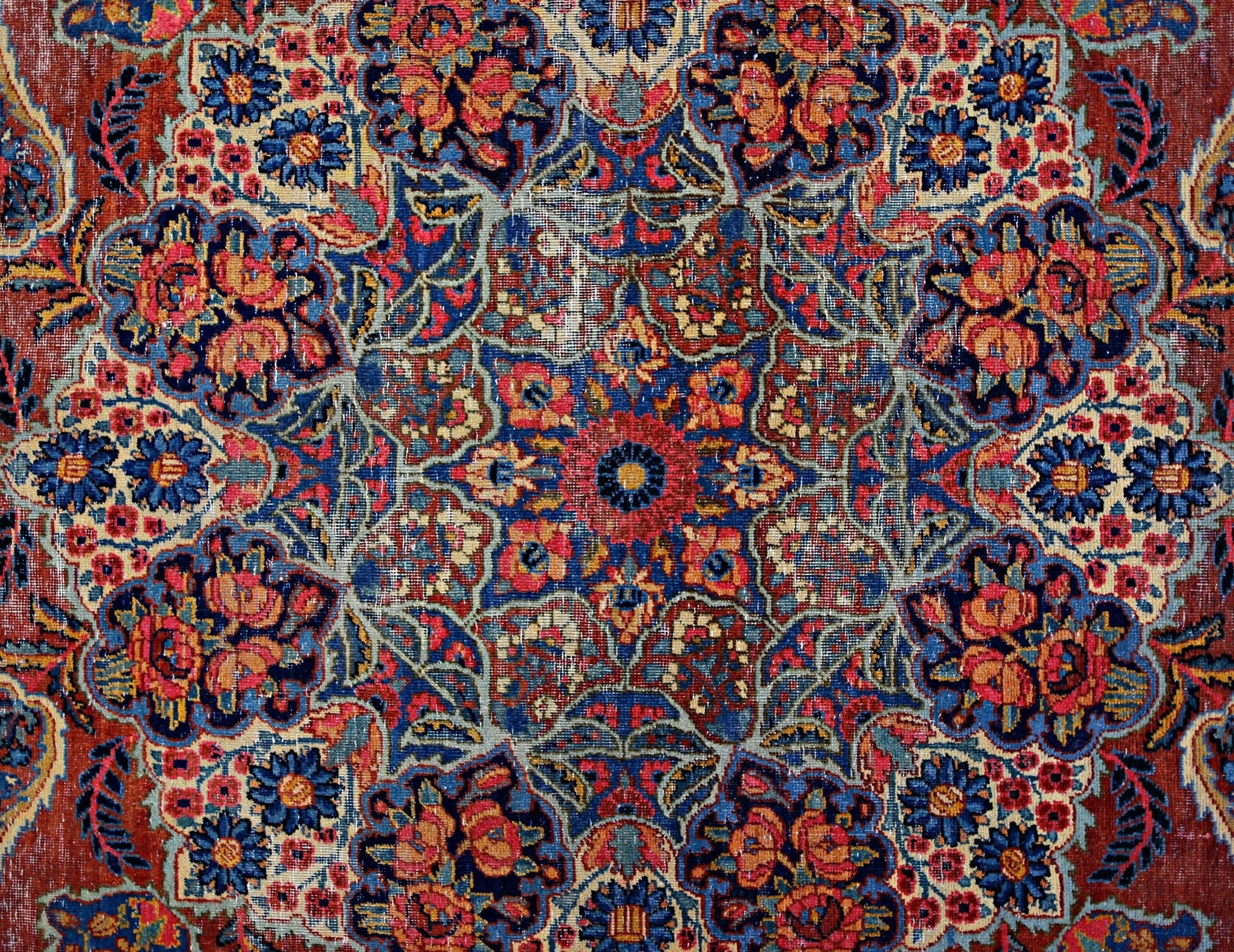 A vintage Persian Moud rug featuring a detailed floral medallion pattern in red and blue tones.