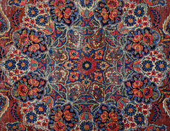 A vintage Persian Moud rug featuring a detailed floral medallion pattern in red and blue tones.