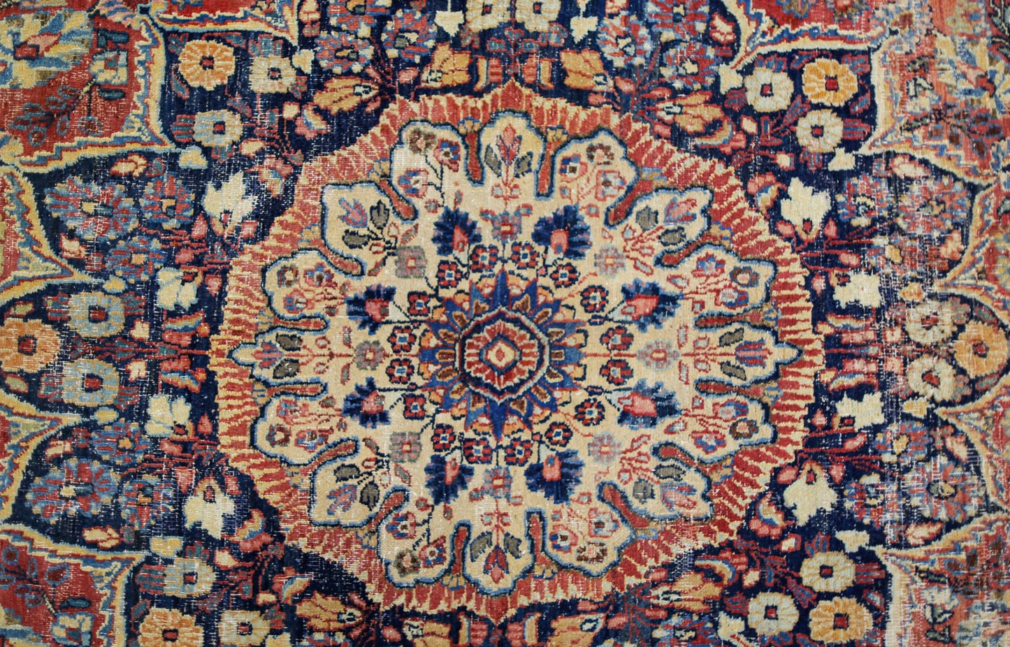 A vintage Persian Moud rug featuring a central floral medallion on a dark blue field.