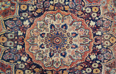 A vintage Persian Moud rug featuring a central floral medallion on a dark blue field.