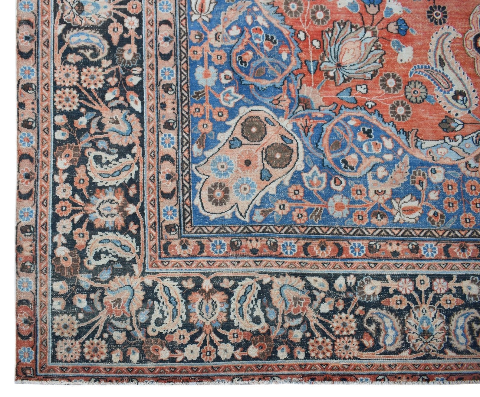 A vintage Persian Moud rug featuring intricate floral patterns in blue, red, and cream tones.