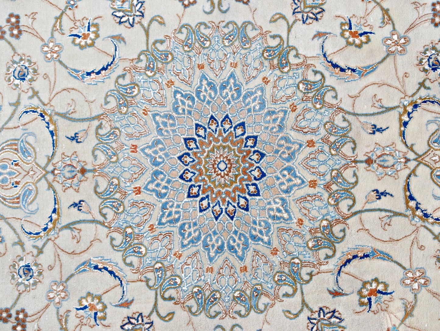 A vintage Persian Nain rug featuring an intricate blue and beige floral medallion pattern.
