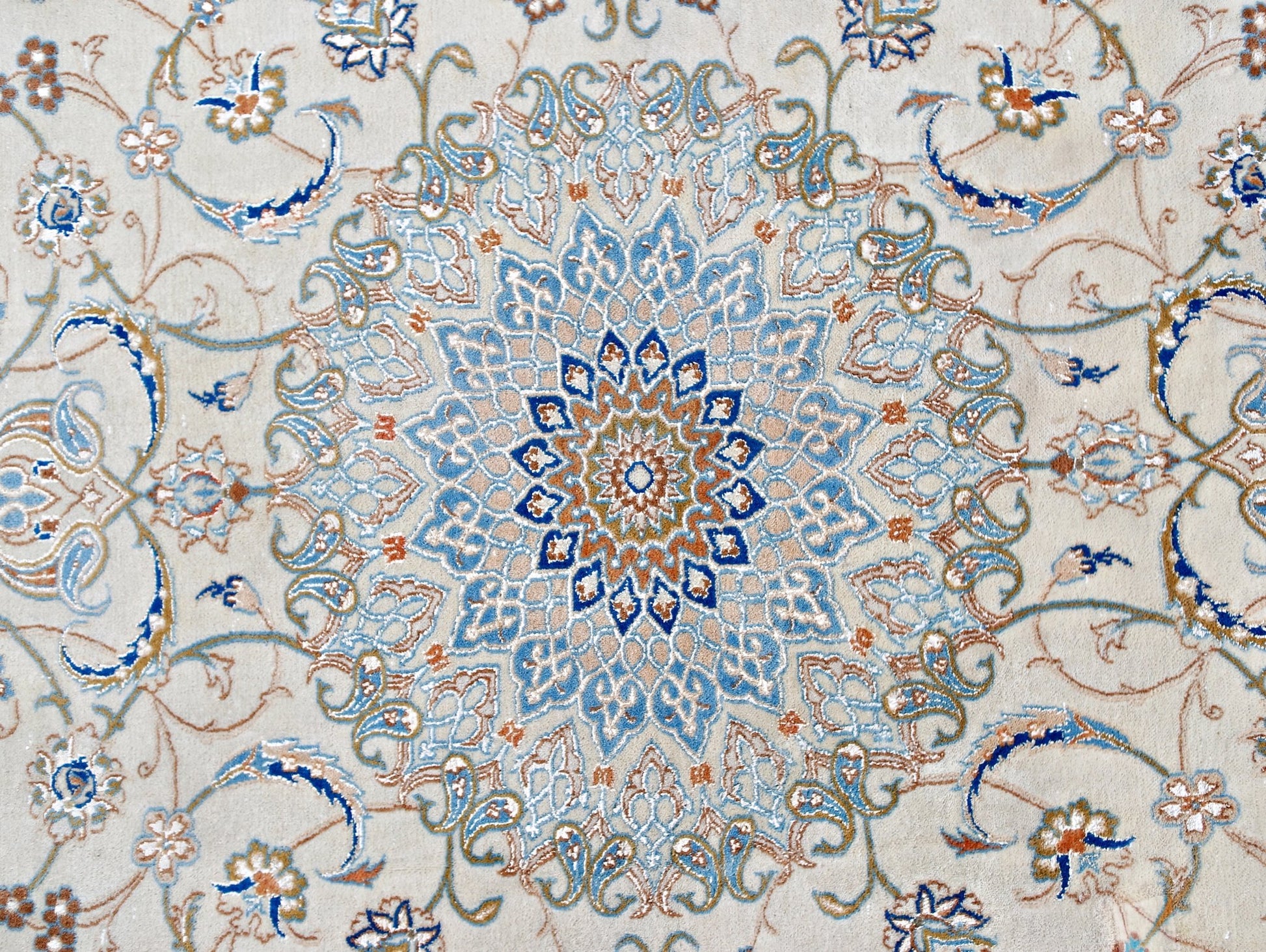 A vintage Persian Nain rug featuring an intricate blue and beige floral medallion pattern.