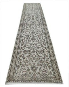 A vintage Persian Nain runner featuring intricate floral patterns in neutral tones.