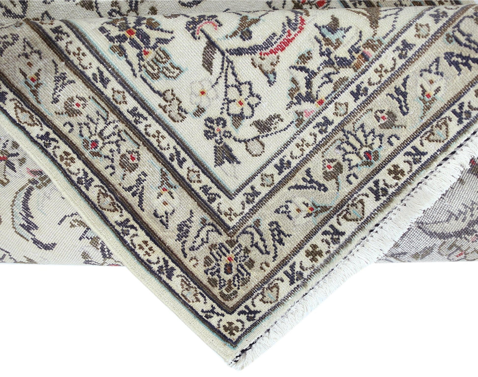 A vintage Persian Nain runner featuring intricate floral patterns in cream, blue, and brown tones.