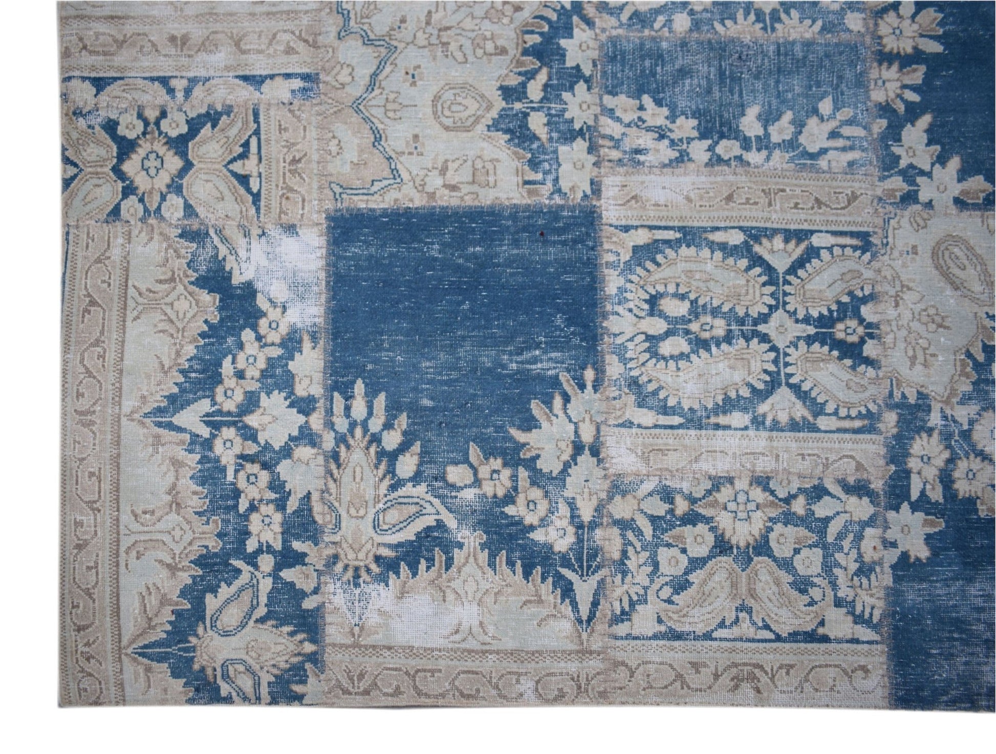 A handmade vintage patchwork rug featuring a blue and beige floral pattern.