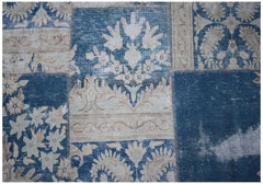 A vintage patchwork rug featuring a blue and beige floral pattern with visible stitched seams.