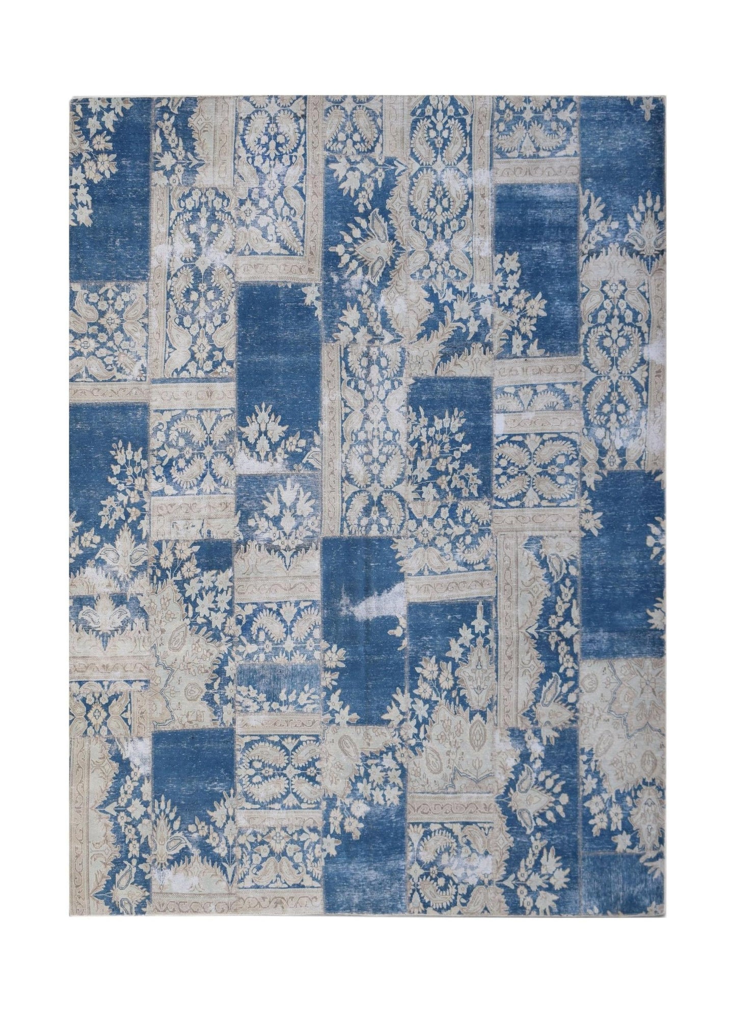 A rectangular patchwork rug featuring a vintage blue and cream floral pattern.
