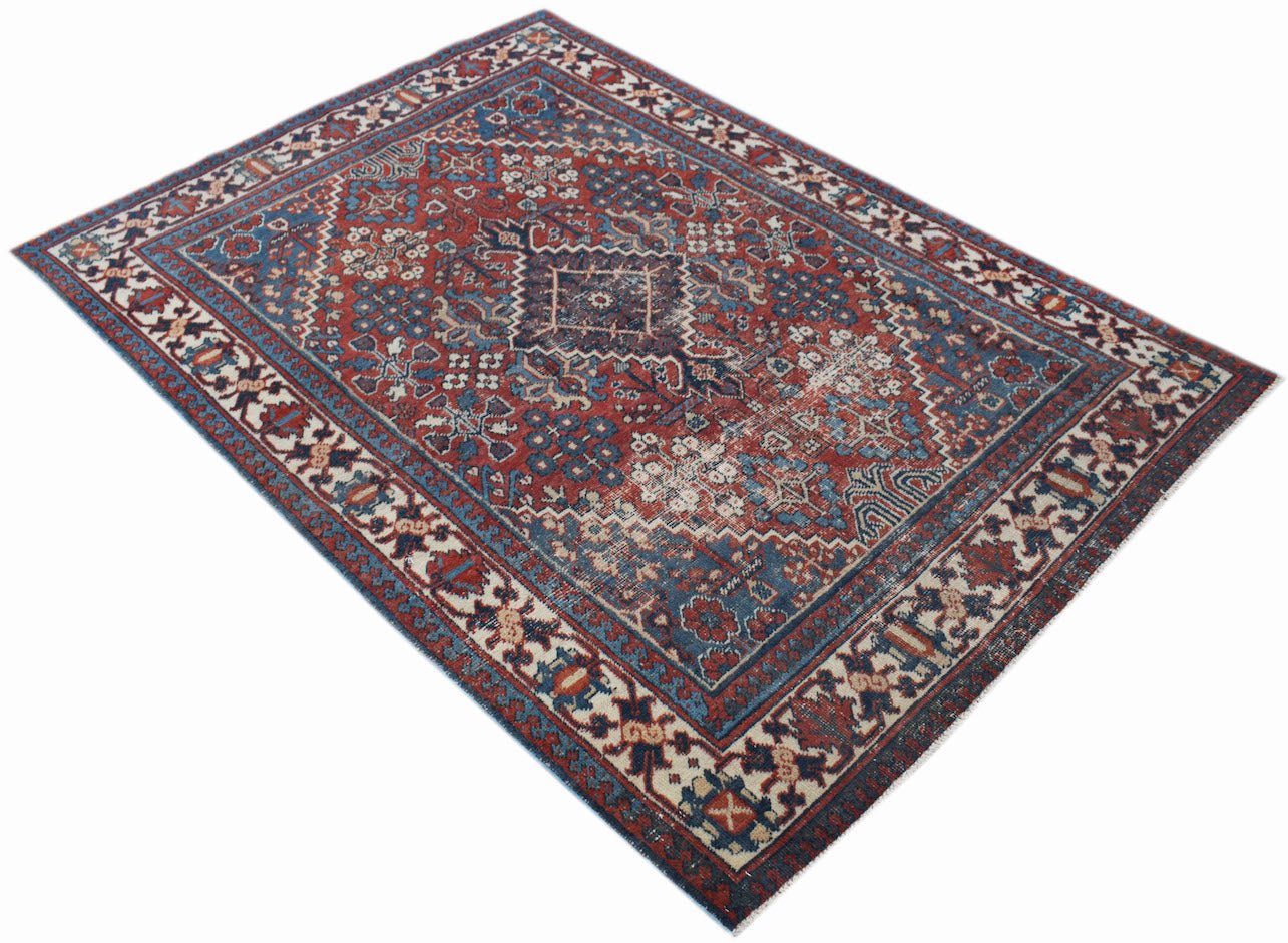 A vintage handwoven Persian Ghashghai rug featuring a traditional geometric pattern in red and blue.